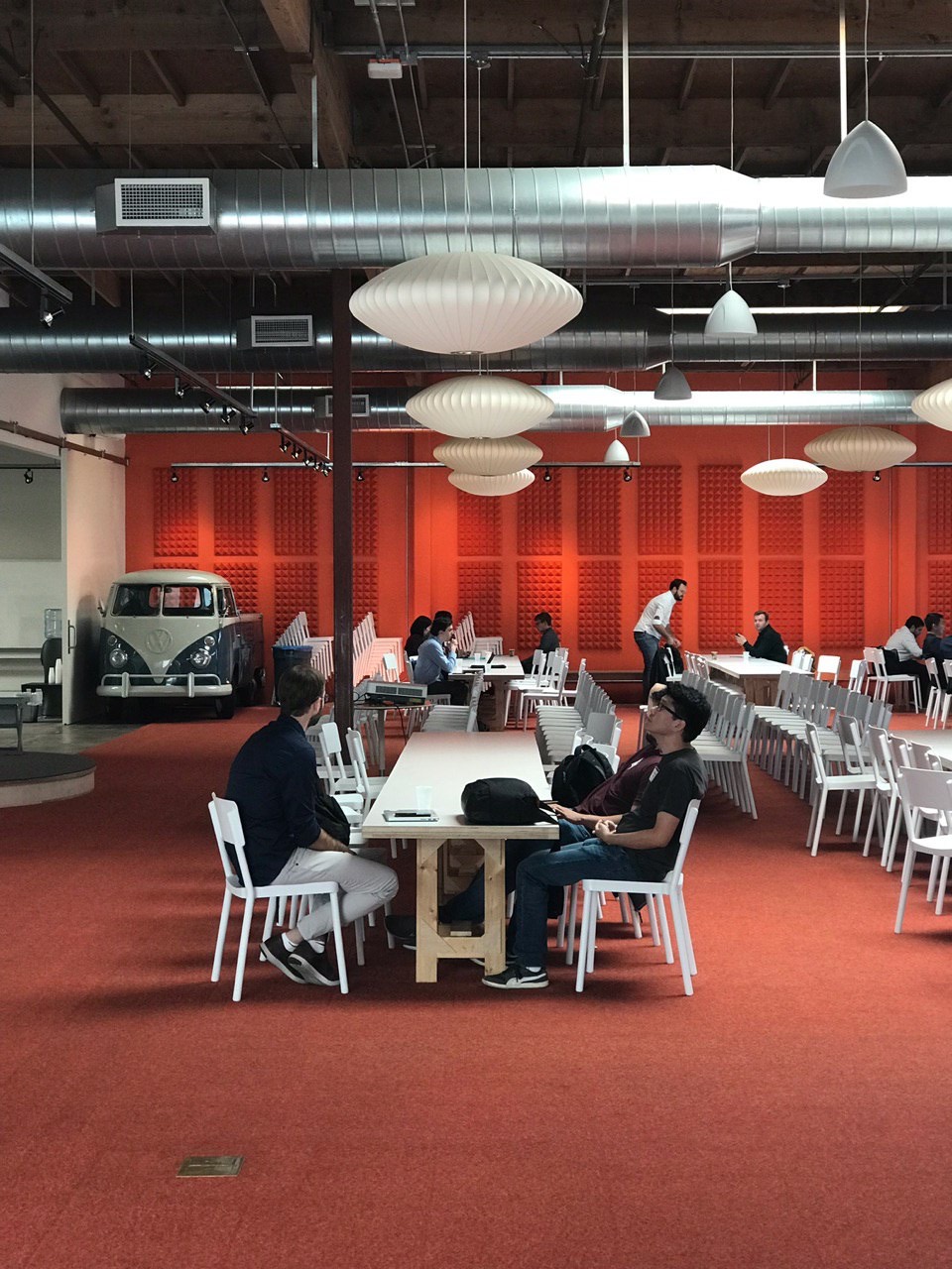 A quiet afternoon in the open-plan office, the vintage van parked against the orange wall