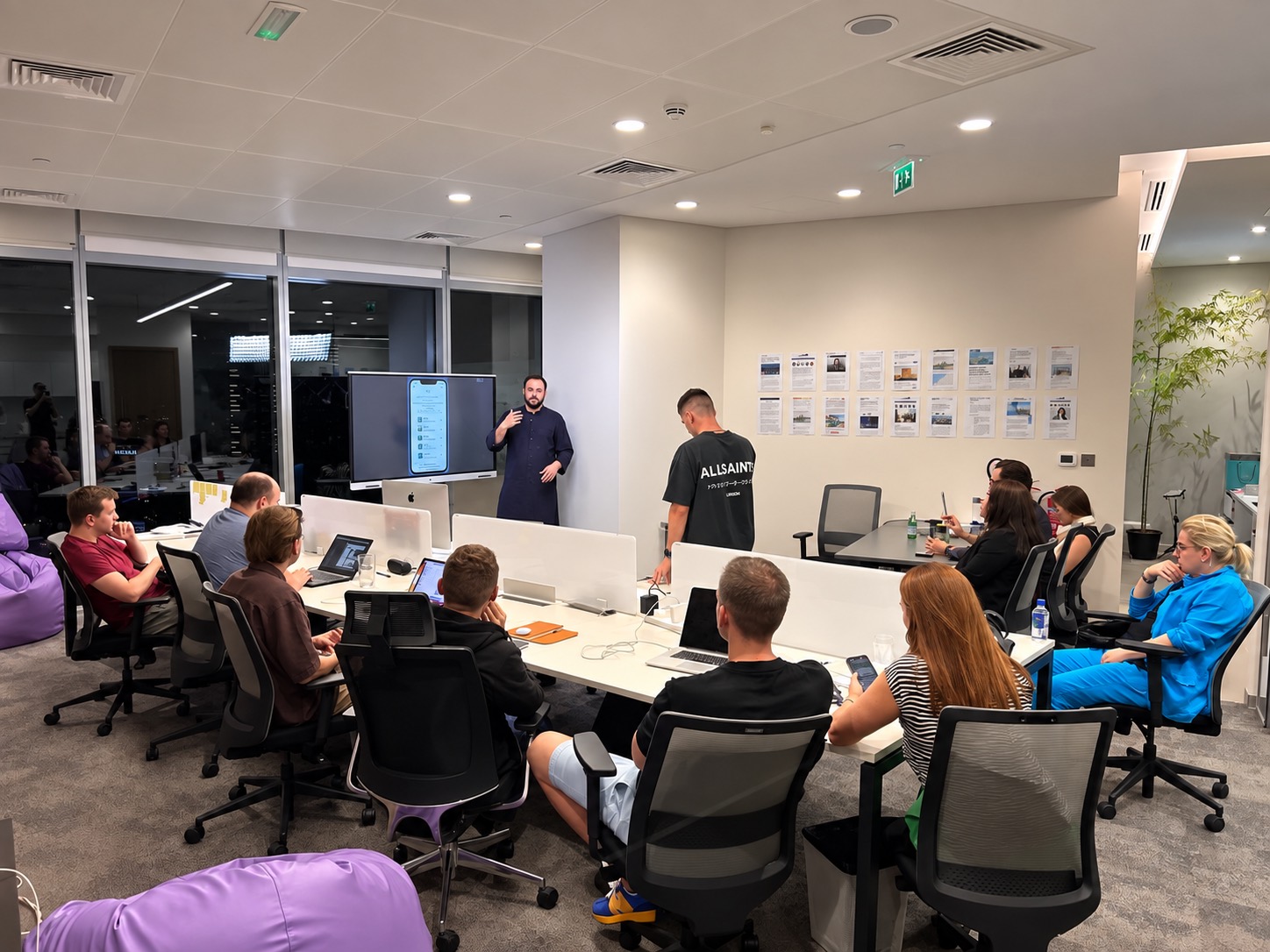 An evening demo in the open-plan office, the mobile app on the big screen